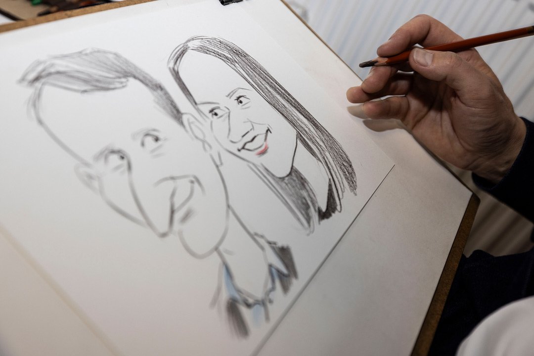 Pāra karikatūra zīmēta ar zīmuli. Abas personas smaida.